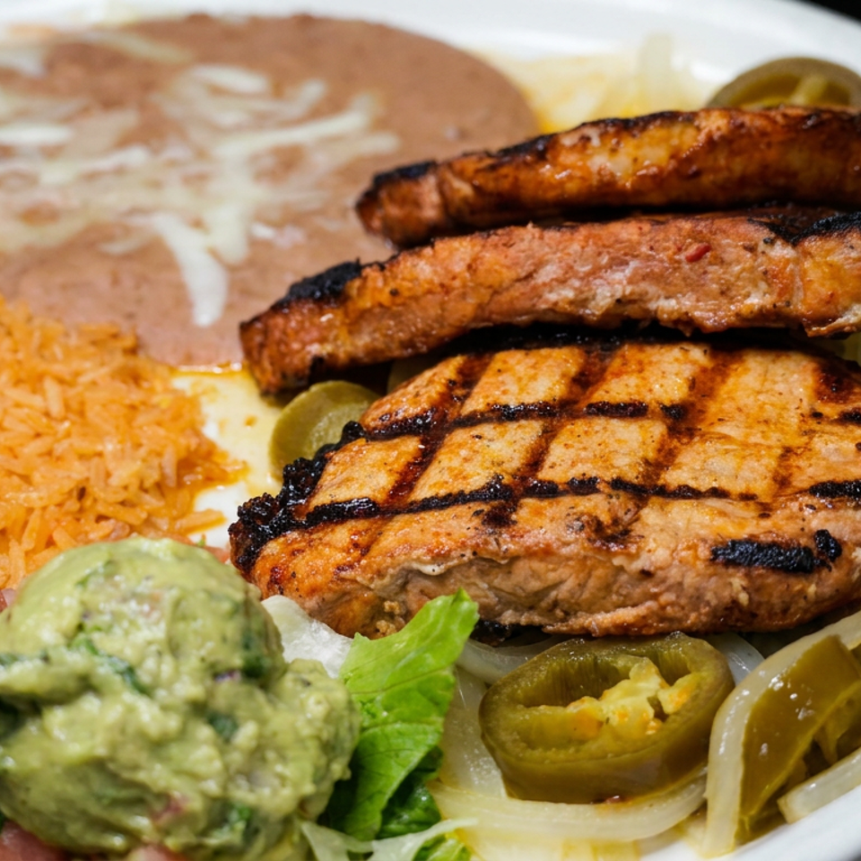 Mexican platter with grilled chicken, steak and sausage, orange rice, refried beans, guacamole, salsa, and pickled jalapeños.